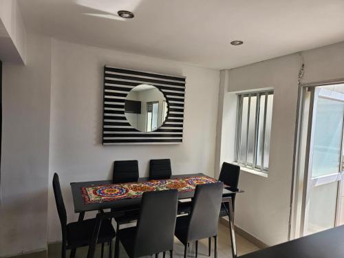 a dining room with a table with chairs and a mirror at LA CASA DEL CABLE - Hermoso Apartamento - in Manizales
