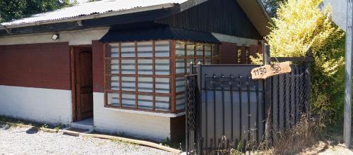 uma pequena casa com um portão e um sinal nele em Casa variante internacional em Pucón