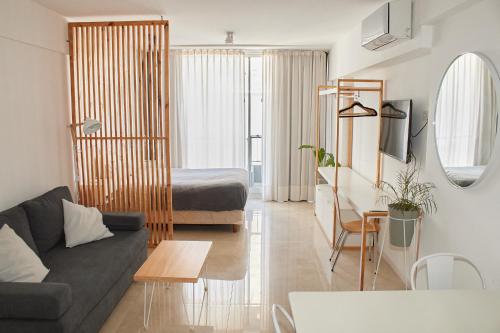 sala de estar con sofá y cama en Moderno y Confortable en pleno centro de BsAs! Divino para 3 pax en Buenos Aires