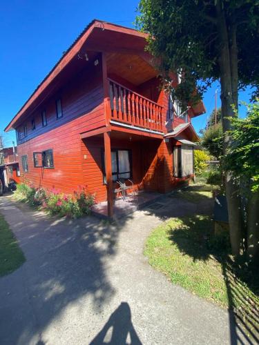 a large wooden house with a deck on the side of it at Casa Licanray in Licán Ray