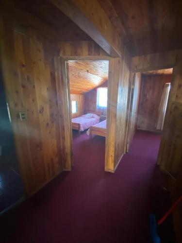 a room with two beds in a wooden cabin at Casa Licanray in Licán Ray