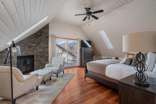 a bedroom with a bed and a fireplace at Parkland301 Sunlit 2,000 ft² Penthouse with Mtn View in Canmore