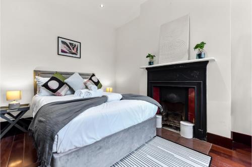 a bedroom with a bed and a fireplace at Lovely 2-bedroom rental unit in Greater London in Hanwell