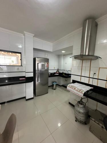 uma grande cozinha com um frigorífico de aço inoxidável em APARTAMENTO IMPERIAL IV (COMPLETO) em Castanhal
