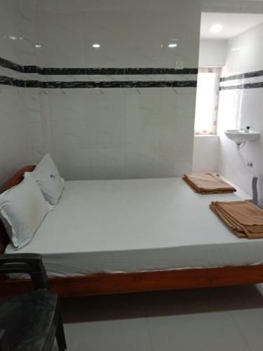 SrīsailamにあるGrand siri hotel and lodgeの窓付きの客室で、白い大型ベッド1台が備わります。