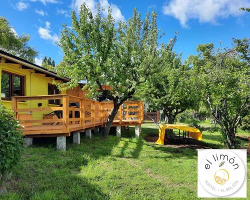 a tree house with a playground in the yard at HOSTEL EL LIMON in El Bolsón