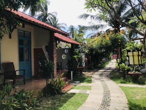 a house with a pathway next to a building at Nhat Quang Bungalow in Mui Ne