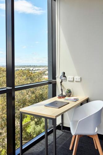 an office with a desk and a chair and a window at Together Co-Living Melbourne in Melbourne