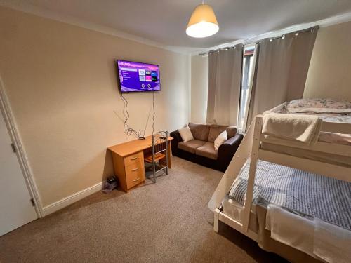 a bedroom with a bed and a tv on a wall at London Whitechapel Mile End in London