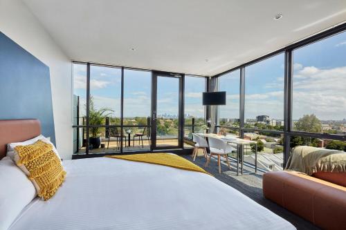 a bedroom with a bed and a large window at Together Co-Living Melbourne in Melbourne