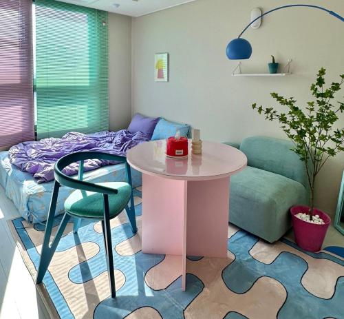 een woonkamer met een tafel en een bed bij Dongseongro meomoom in Daegu