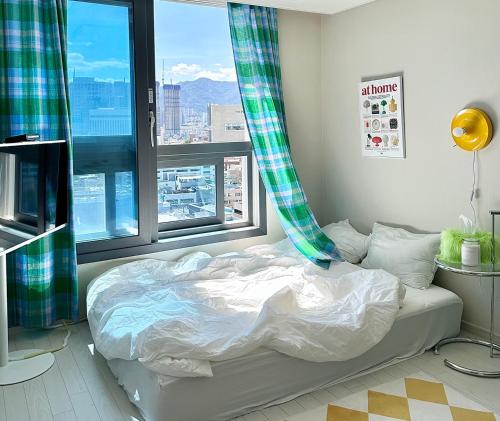 łóżko w pokoju z dużym oknem w obiekcie Dongseongro meomoom w mieście Daegu
