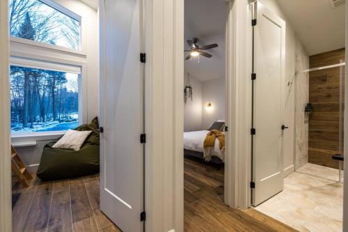 a room with a bedroom with a bed and a window at Chalet TERRE en harmonie avec la nature, Tremblant in Lac-Superieur