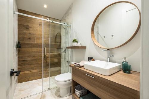 a bathroom with a sink and a shower with a mirror at Chalet TERRE en harmonie avec la nature, Tremblant in Lac-Superieur