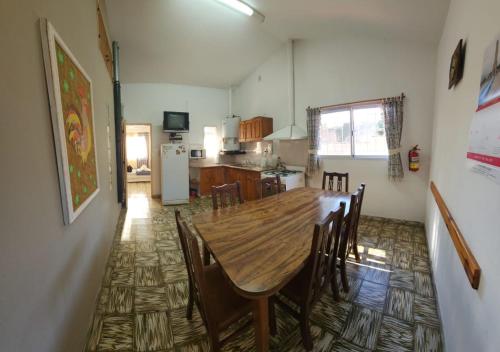 a kitchen and dining room with a wooden table and chairs at Lorena Houses in Capilla del Monte