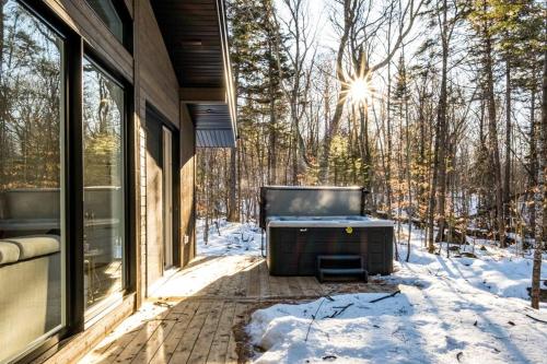 a screened in porch with snow on the ground at Chalet TERRE en harmonie avec la nature, Tremblant in Lac-Superieur
