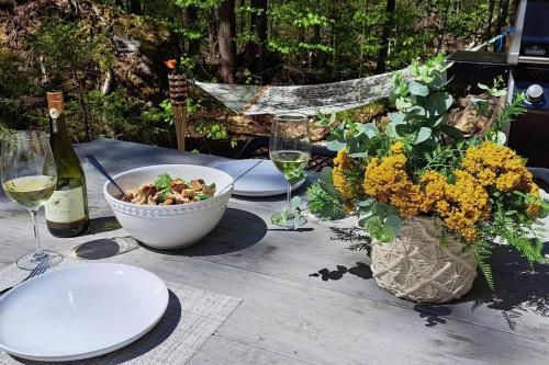 a table with a bowl of food and a bottle of wine at Chalet TERRE en harmonie avec la nature, Tremblant in Lac-Superieur