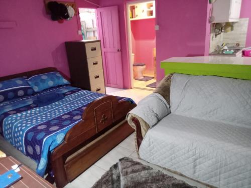 1 dormitorio con cama y sofá en Caribb Home and Taxi Service, en Bridgetown