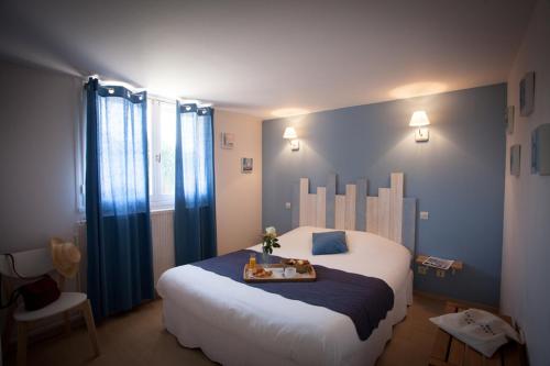 a bedroom with a large bed with a tray on it at Hôtel La Ferme d'En Chon in Biscarrosse