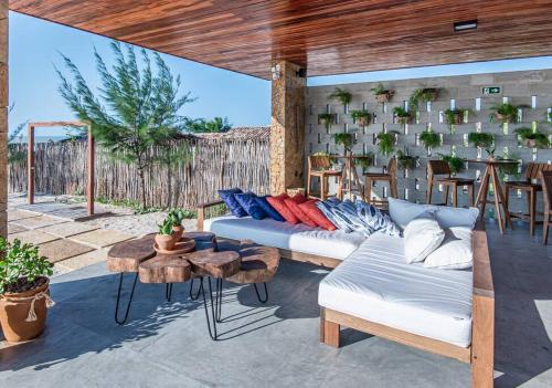 eine Terrasse mit einem Sofa, einem Tisch und Stühlen in der Unterkunft Vila Cangalha in Camocim
