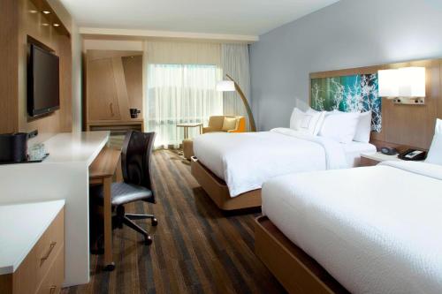 a hotel room with two beds and a desk at Courtyard by Marriott Knoxville West/Bearden in Knoxville