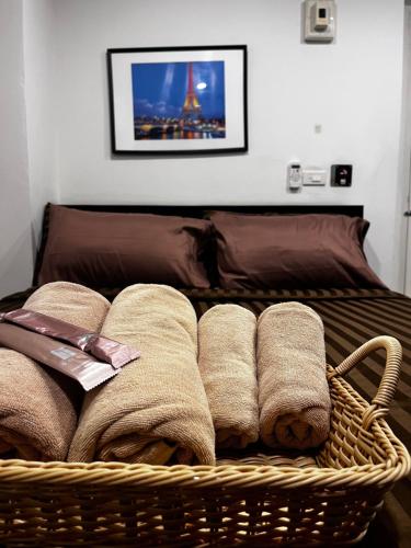 uma cesta cheia de toalhas numa cama em Me Apartment em Ban Talat Rangsit