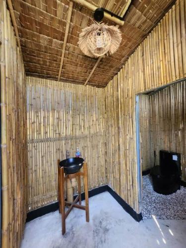 a room with a stool and a chandelier at Kaitoon's River House in Ratchaburi