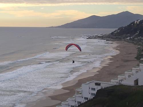 a person flying a kite on the beach at Cabaña Los Laureles in Maitencillo