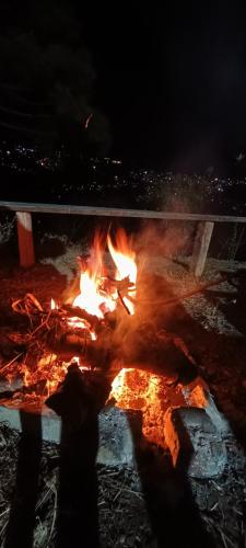 a fire with a person standing in front of it at TREE HOUSE BY THE CITY ESCAPE in Shimla