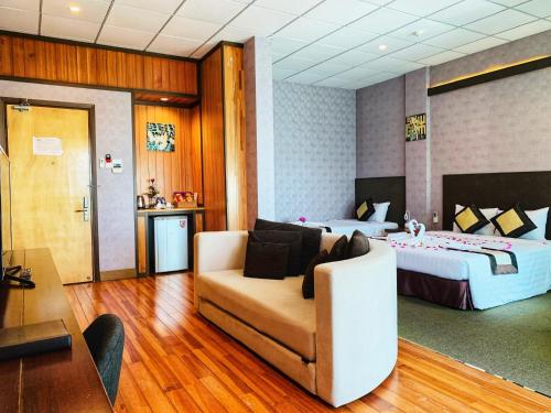 ブンタウにあるニュー ウェーブ ブン タオ ホテルのベッドとソファ付きのホテルルーム