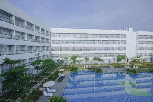 a building with a swimming pool in front of a building at Raja Hotel Kuta Mandalika Resort & Convention in Kuta Lombok