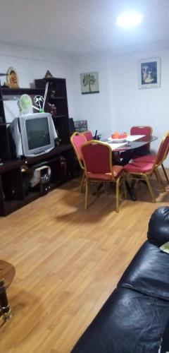 ein Wohnzimmer mit einem Tisch und Stühlen sowie einem TV in der Unterkunft Departamento casa en arica in Arica