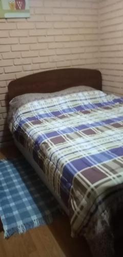 a bed with a blue and white quilt on it at Departamento casa en arica in Arica