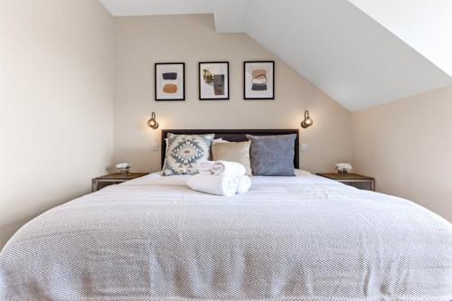 a white bed with a stuffed animal on top of it at Chic Retreat Residences: 3 BD Haven - Sleeps 10 in London