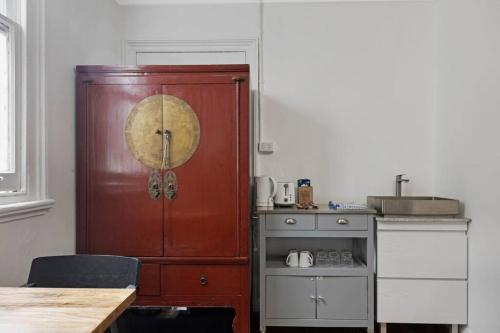 una cocina con un armario rojo y una mesa en Budget 1 bed Private Studio close to Ashfield Station en Sídney