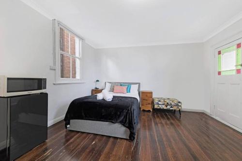 a white room with a bed and a television at Budget 1 bed Private Studio close to Ashfield Station in Sydney