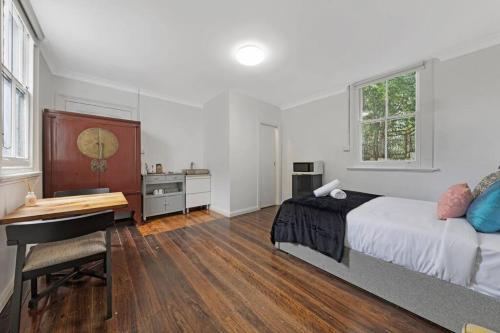 1 dormitorio con cama y escritorio. en Budget 1 bed Private Studio close to Ashfield Station en Sídney