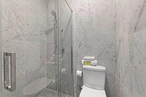a bathroom with a toilet and a glass shower at Budget 1 bed Private Studio close to Ashfield Station in Sydney