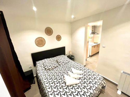 una camera da letto con un letto bianco e nero con due asciugamani di Apartamentos con baño privado frente al metro L5 Barcelona-Hospitalet a Hospitalet de Llobregat