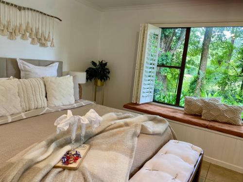 Maleny Lake Cottages في ماليني: غرفة نوم بسرير كبير مع نافذة