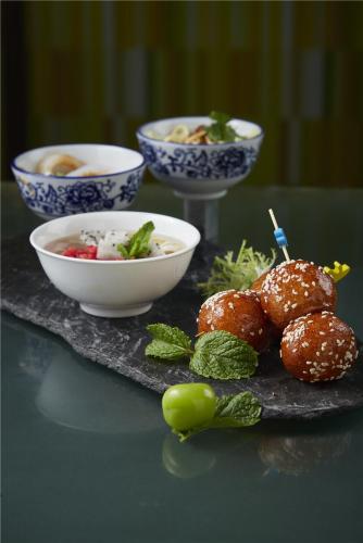 a table with bowls of food and a plate of food at Sheraton Chengdu Lido Hotel in Chengdu