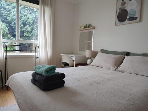 una camera da letto con un letto e asciugamani di Queen Bed on Burton a Lalor