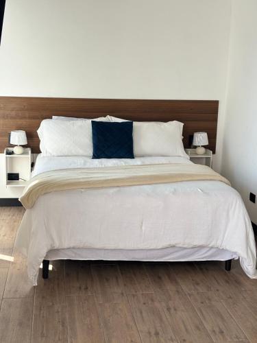 a bedroom with a large white bed with two lamps at EON CITY in Guatemala