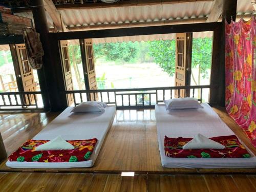 two beds sitting on the floor in a room at Dao homestay Vũ Linh in Yên Bình