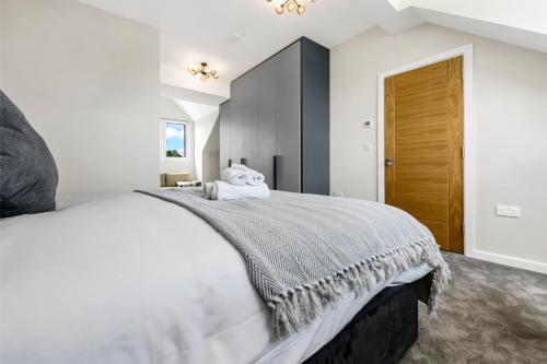 - une chambre avec un grand lit blanc et une porte marron dans l'établissement Luxe and Cozy Living - Family Perfect! Sleeps 9, à Londres