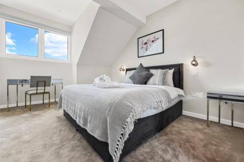 - une chambre blanche avec un grand lit et un bureau dans l'établissement Luxe and Cozy Living - Family Perfect! Sleeps 9, à Londres