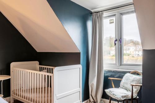 Habitación para bebés con cuna y ventana en Folkestone Ramblers Rest en Kent