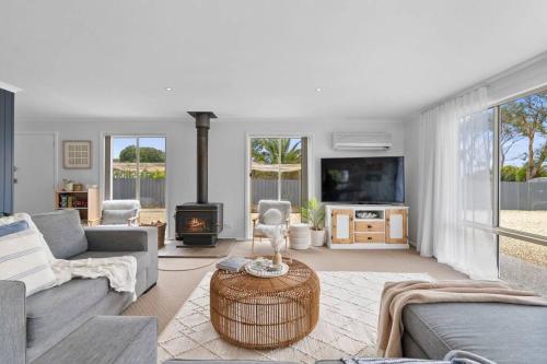 a living room with a couch and a fireplace at Salty Air Cottage in Bream Creek