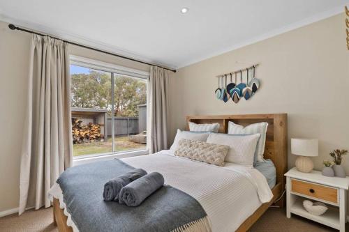 a bedroom with a bed and a large window at Salty Air Cottage in Bream Creek