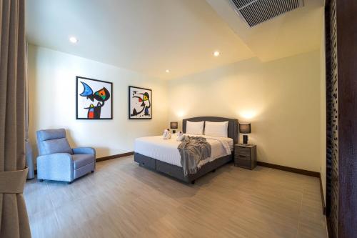 a bedroom with a bed and a blue chair at Luxury 5 Bedroom Villa Close to Beach SRS in Hua Hin